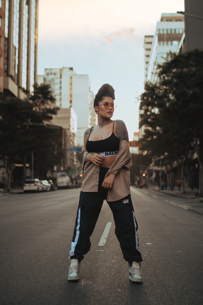 Stylish woman poses confidently on a city street, showcasing urban fashion.